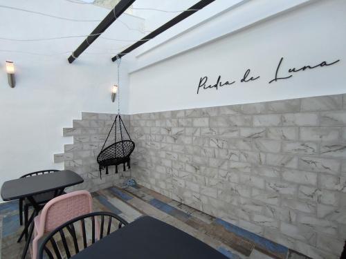 a room with a stone wall with two chairs and a table at PIEDRA DE LUNA in Merida