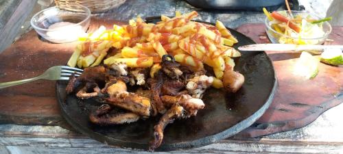 a plate of food with meat and french fries at Stilts Diani Beach in Diani Beach