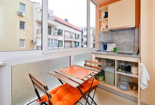 uma varanda com mesa e cadeiras e uma cozinha em Студио Патрисия em Pomorie