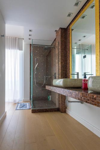 a bathroom with a shower and a sink and a mirror at Sapphire Luxury Villa in Iraklitsa