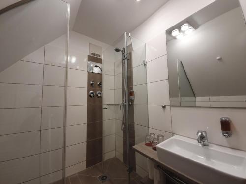a bathroom with a shower and a sink at Avenon Privathotel Schwaiger Hof in Schwaig bei Nürnberg