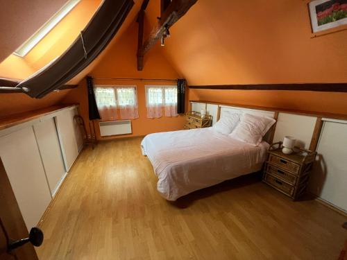 una camera con letto e pavimento in legno di LES FLORALIES a Froberville