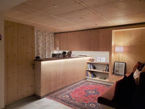 a kitchen with wooden cabinets and a rug in a room at Pension Waldhof in Lech am Arlberg