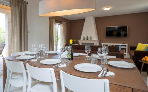 a dining room with a table and white chairs at Hvaretta Villas in Stari Grad
