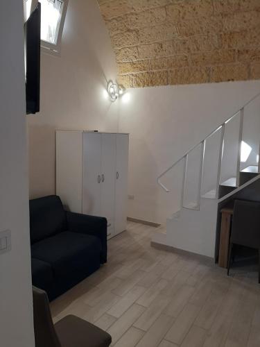 ein Wohnzimmer mit einem Sofa und einer Treppe in der Unterkunft Casa di Carmine 2 in Galatina