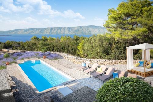 een villa met een zwembad en uitzicht op het water bij Hvaretta Villas in Stari Grad