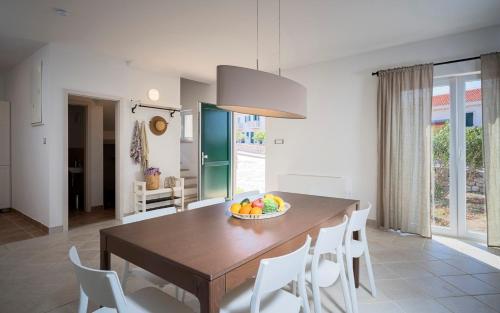 a kitchen and dining room with a wooden table and chairs at Hvaretta Villas in Stari Grad