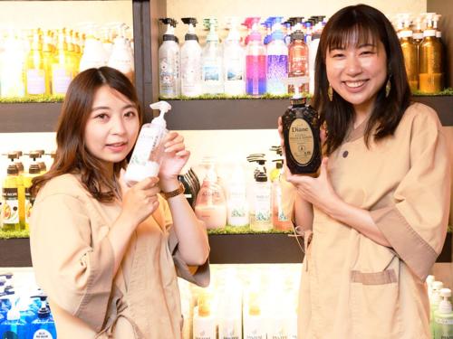 two women standing in a store holding bottles at A-GATE HOTEL 旭川 -Asahikawa- in Asahikawa