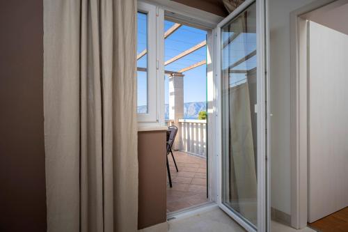 a glass door leading to a balcony with a view at Hvaretta Villas in Stari Grad