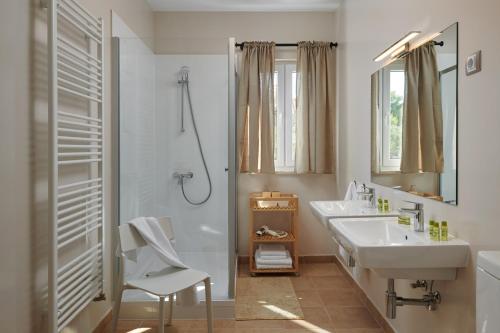 a white bathroom with a sink and a shower at Hvaretta Villas in Stari Grad