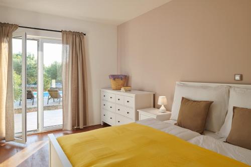 a bedroom with a bed and a sliding glass door at Hvaretta Villas in Stari Grad