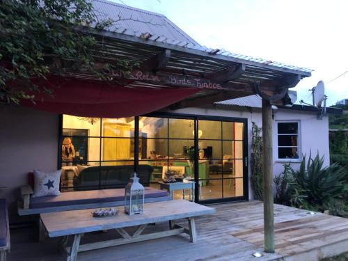 a patio with a picnic table and a house at Baviaanshoek in Keurboomstrand