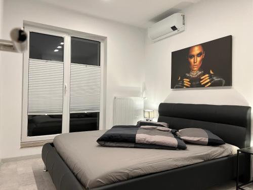 a bedroom with a bed with a picture on the wall at Amazing 2-Room Penthouse Cityview W13 in Bucharest
