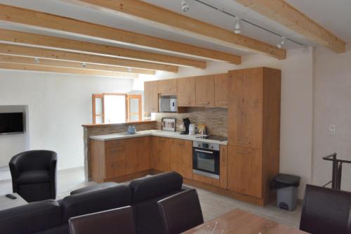 a kitchen with wooden cabinets and a living room at Casa Natalina de caractère entièrement rénovée classée 4 étoiles in Feliceto