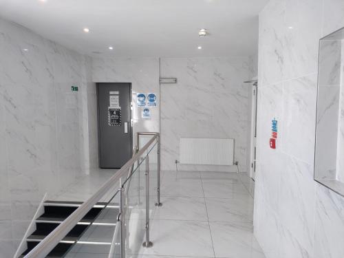 a hallway with a staircase in a building with marble walls at Torbay Court Hotel in Paignton
