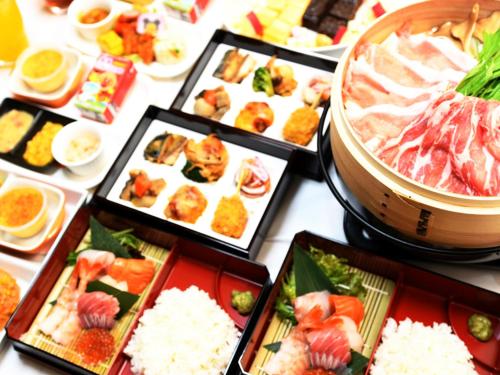 a table filled with different types of sushi and rice at A-GATE HOTEL 旭川 -Asahikawa- in Asahikawa