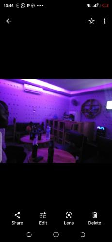 a room with purple lights on the wall and tables at Kicec bar and guest house airport in Dar es Salaam