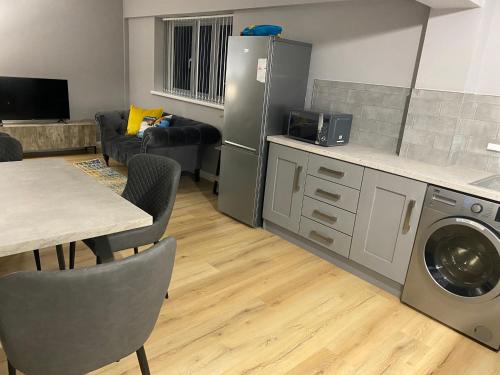 a kitchen with a refrigerator and a table with chairs at Dunlap Apartments in Strabane