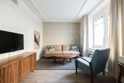 a living room with a couch and a tv at EMA House Serviced Apartments Superior Unterstrass in Zürich