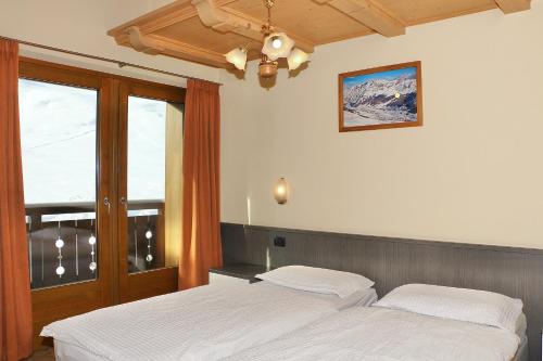 a bedroom with two beds and a window at Casa Peri in Livigno