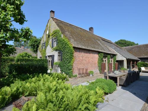 an old brick house with ivy growing on it at Grand Holiday Home in Alphen with Sauna in Alphen