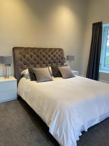 a hotel room with a bed, chair, and nightstand at Woodlands Hall Hotel in Ederyn
