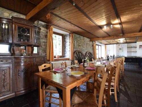 une salle à manger avec une grande table et des chaises en bois dans l'établissement Quaint Cottage In Petite Langlire With bubble bath, à Langlir