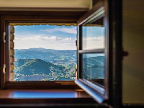a window with a view of a mountain view at Hidden Hamlet Stay with Pool in SantʼAngelo in Vado