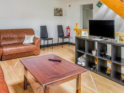 uma sala de estar com um sofá, uma mesa e uma televisão em Holiday Home near Ravel Cycling paths em Heuem