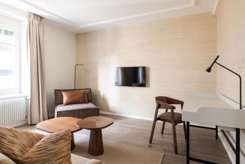 a living room with a couch a table and a tv at EMA House Serviced Apartments Superior Unterstrass in Zürich