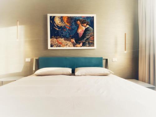 a bedroom with a bed with a painting on the wall at Borgomarino 32 in Pescara