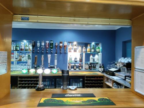 a bar in a restaurant with a blue wall at Torbay Court Hotel in Paignton