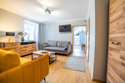 ein Wohnzimmer mit Couch und Tisch in der Unterkunft Gościniec pod Lilijką in Podzamcze