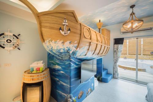 花蓮市的住宿－彤話故事親子主題民宿，墙上有一艘大型木船的房间