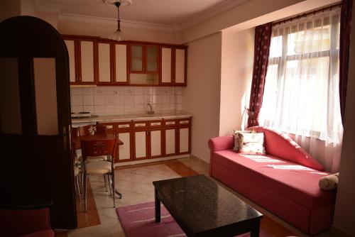 a living room with a red couch and a kitchen at AKASYA VADİSİ in Kızılcahamam
