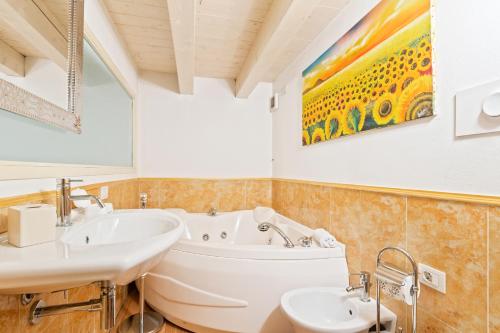a bathroom with two sinks and a tub and a painting at Loft di Design Porta Romana/Corso Lodi in Milan