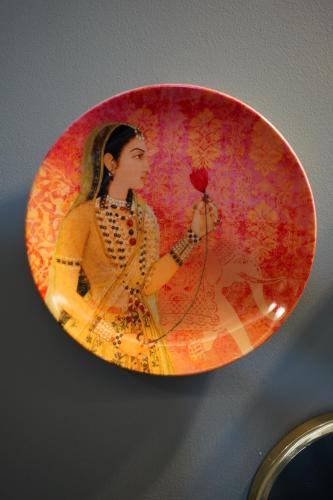 a plate with a picture of a woman holding a rose at Ekaa Villa near Taj Mahal in Agra