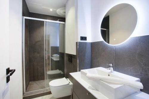 ein Badezimmer mit einem WC, einem Waschbecken und einem Spiegel in der Unterkunft Apartment Palais Royal by Studio prestige in Paris