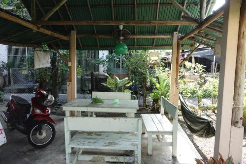 a table and a scooter parked under a pavilion at Orchid Guest House in Trat
