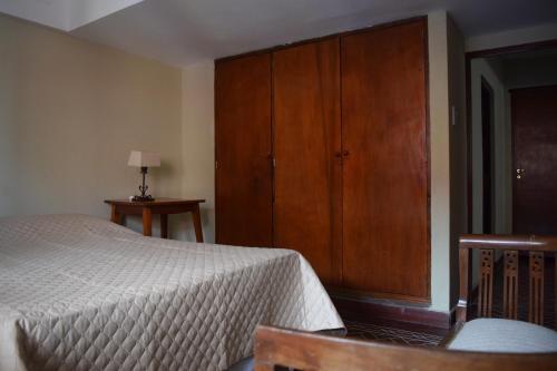 1 dormitorio con 1 cama y armario de madera en El duplex de Jaleo en El Carmen