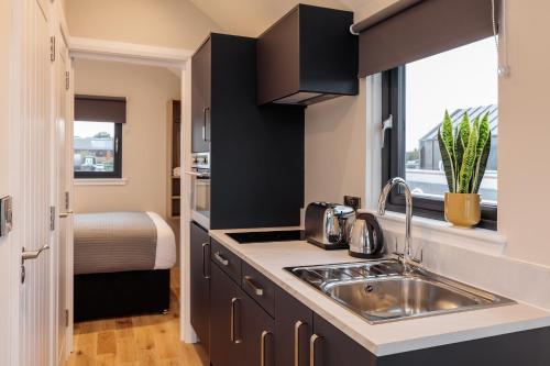 una cocina con fregadero y una cama en una habitación en Tattenhall Marina Floating Pods en Hargrave