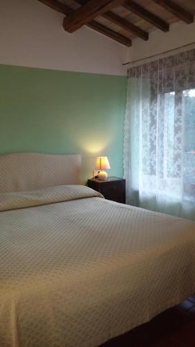 a bedroom with a white bed and a window at Ca' le Suore in Cagli