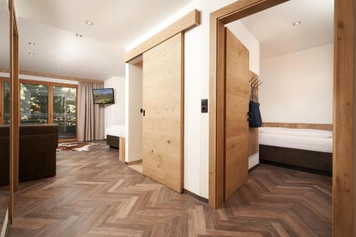 a room with a hallway with a sliding door at Hotel Gundolf in Sankt Leonhard im Pitztal