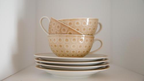 two cups sitting on top of a stack of plates at Combo Rooms in Garna dʼAlpago