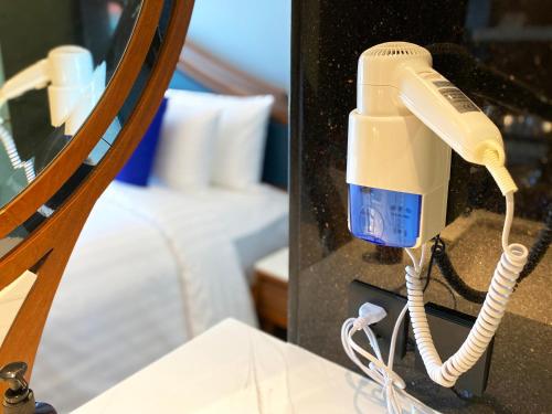 a phone in a room with a bed at The Oceanic Sportel Phuket - SHA Extra Plus in Phuket Town