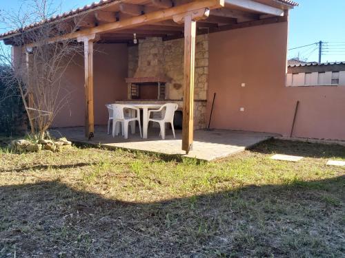 un patio avec une table et des chaises sous une pergola dans l'établissement Sunshine summer house, à Paralia Dionisiou