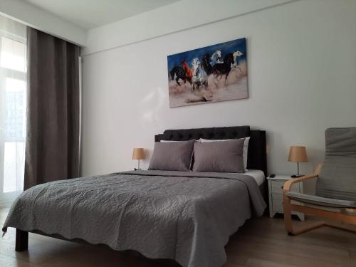 1 dormitorio con 1 cama y una pintura en la pared en Luxury City Center Apartment – Garofita Romana, en Bucarest