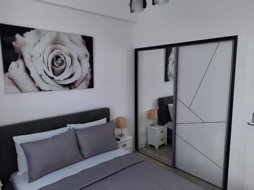 een slaapkamer met een bed en een bloem op de muur bij Luxury City Center Apartment – Garofita Romana in Boekarest