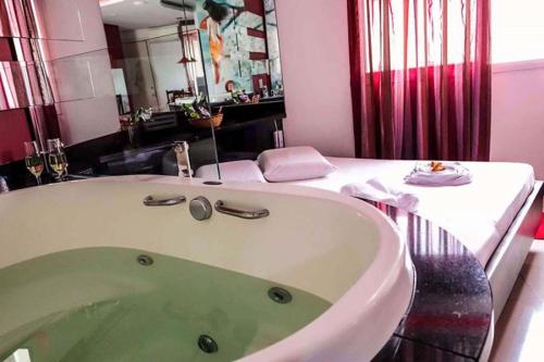 a bath tub in a bathroom with a sink at Taikô Motel by Drops in Porto Alegre