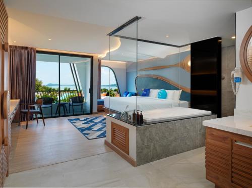 a bedroom with a king sized bed and a bathroom at The Oceanic Sportel Phuket - SHA Extra Plus in Phuket Town